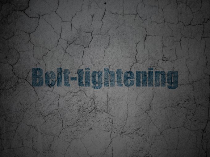 Business concept: Belt-tightening on grunge wall background