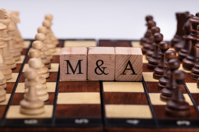 Wooden Blocks With Mergers And Acquisitions Text On Chess Board