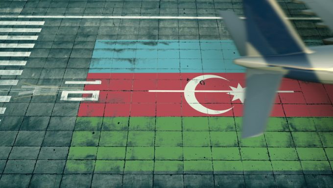 Aerial view of a landing airplane revealing flag of Azerbaijan on the airfield of an airport. Air travel related conceptual 3D rendering