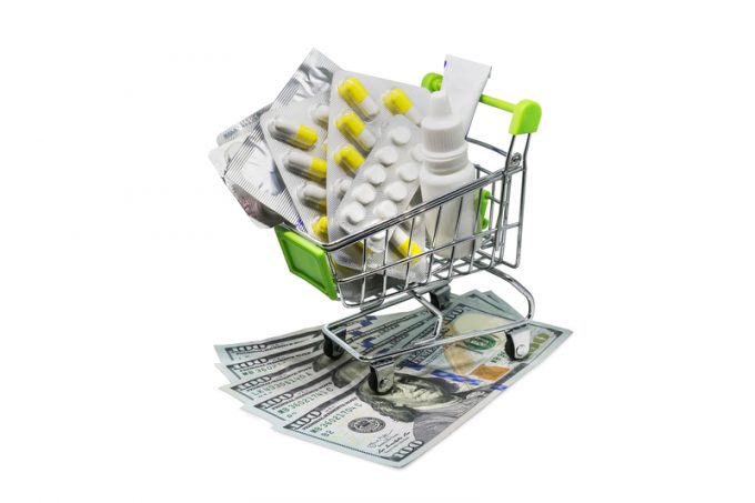 Prescription drugs on money representing rising health care costs.