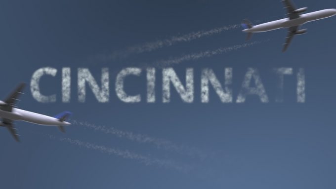 Flying airplanes trails and Cincinnati caption. Traveling to the United States conceptual 3D rendering