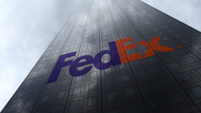 FedEx logo on a skyscraper facade reflecting clouds. Editorial 3D rendering