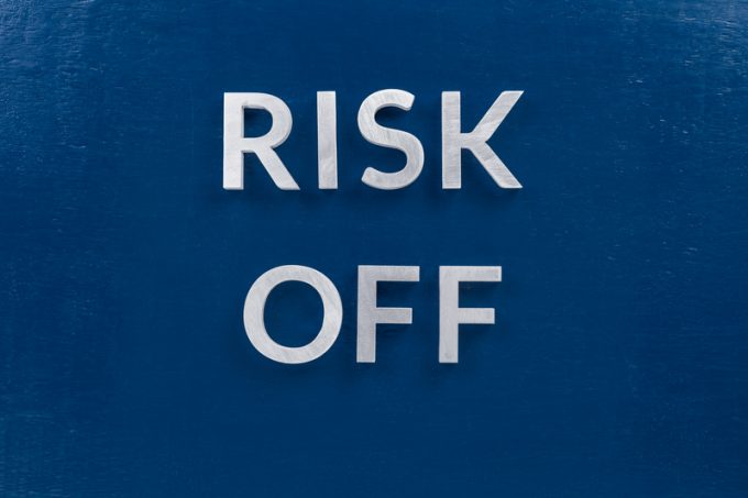 the words risk off laid with silver metal letters on classic blue surface for stock market background