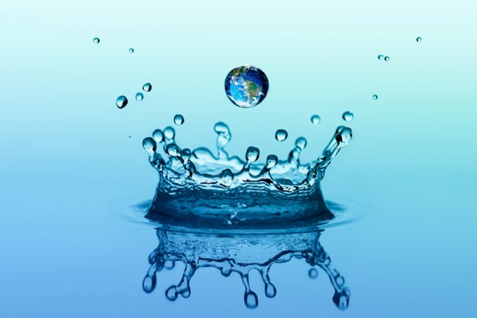 Water splash in crown shape and falling drop with earth image