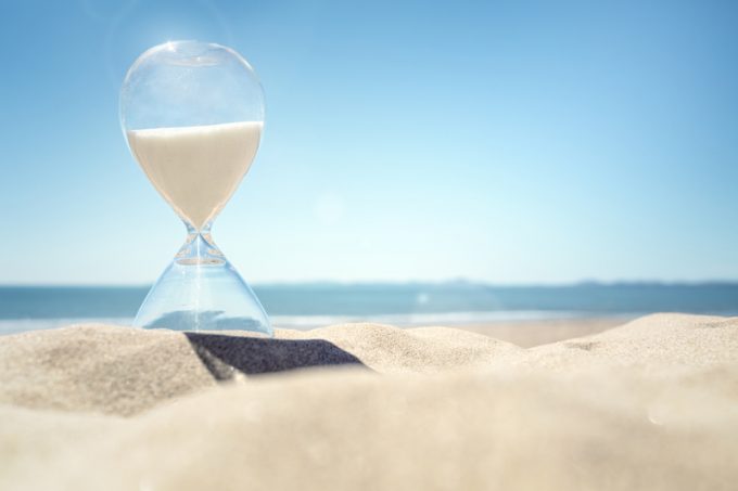 Hourglass time on a beach in the sand