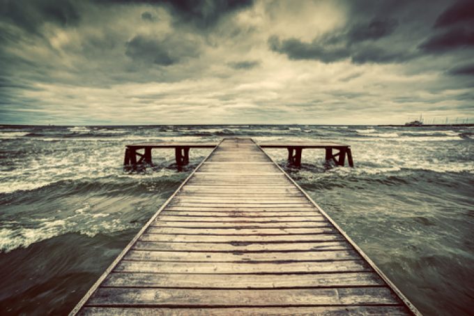 Old wooden jetty, pier, during storm on the sea.