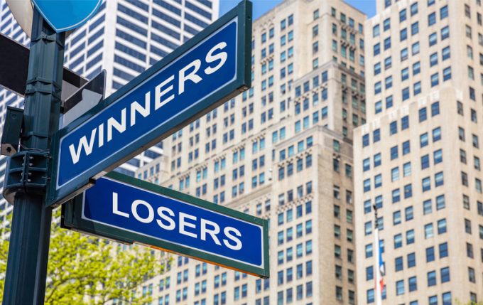 Winners losers crossroads street sign. Highrise buildings background,